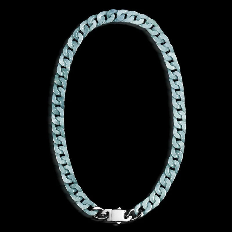 A blue jade Cuban link chain necklace arranged in an oval shape against a solid black background
