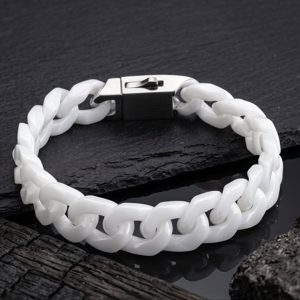 A white Jade cuban-link bracelet with a silver-toned padlock clasp, displayed on a dark slate surface.