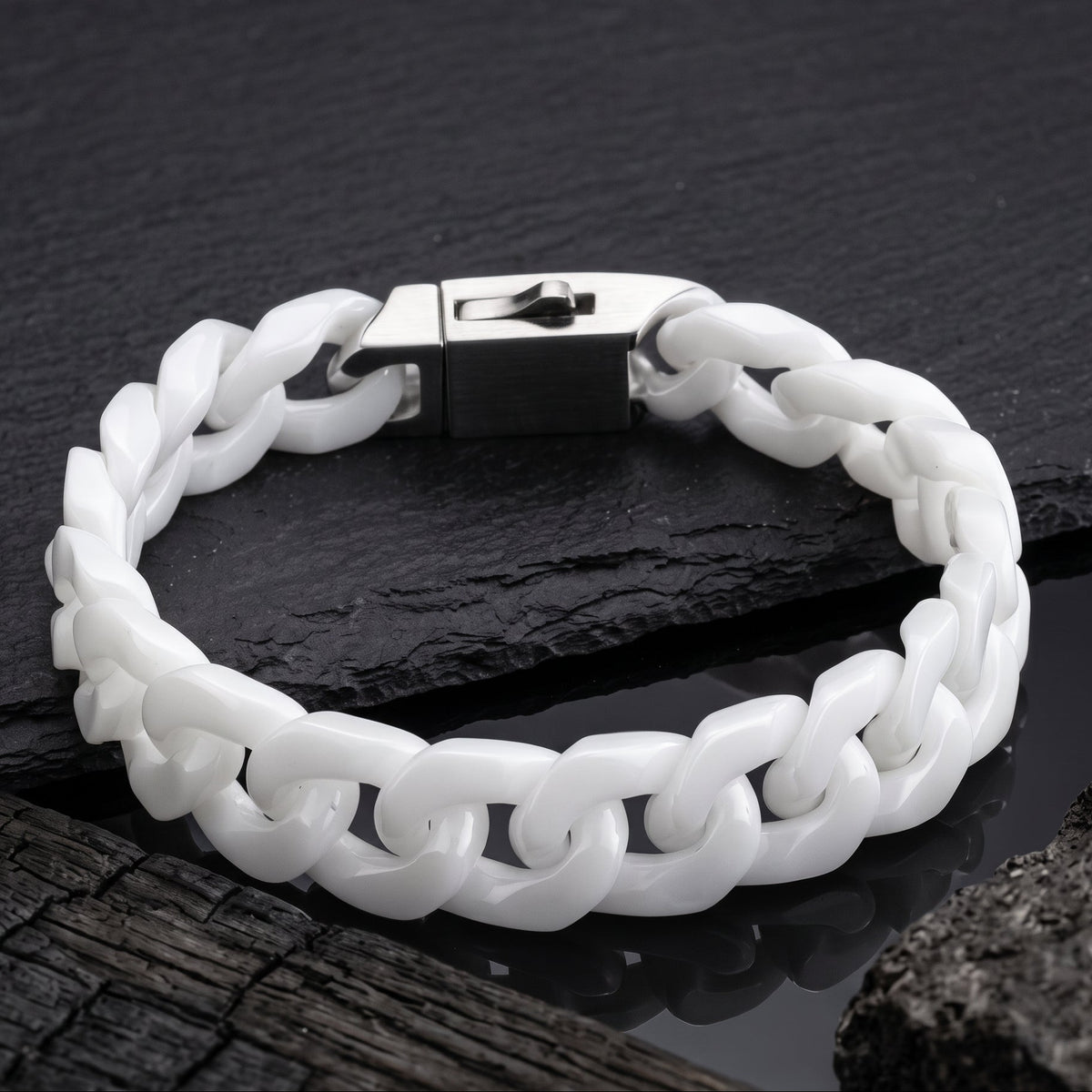 A white Jade cuban-link bracelet with a silver-toned padlock clasp, displayed on a dark slate surface.